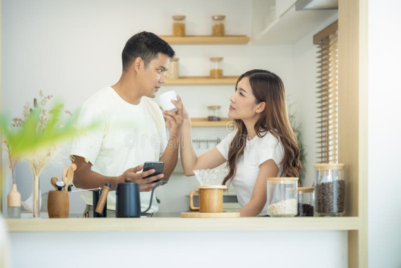Couple, 2 people or lover to made, drink coffee together in kitchen, home in morning. Include coffee cup or mug, blind and light from window. Concept for lifestyle, love, happy, family, relationship. Couple, 2 people or lover to made, drink coffee together in kitchen, home in morning. Include coffee cup or mug, blind and light from window. Concept for lifestyle, love, happy, family, relationship.