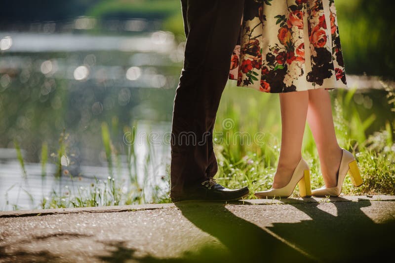 Couple kissing outdoors - Lovers on a romantic date at sunset,girls stands on tiptoe to kiss her man - Close up on shoes. Couple kissing outdoors - Lovers on a romantic date at sunset,girls stands on tiptoe to kiss her man - Close up on shoes.