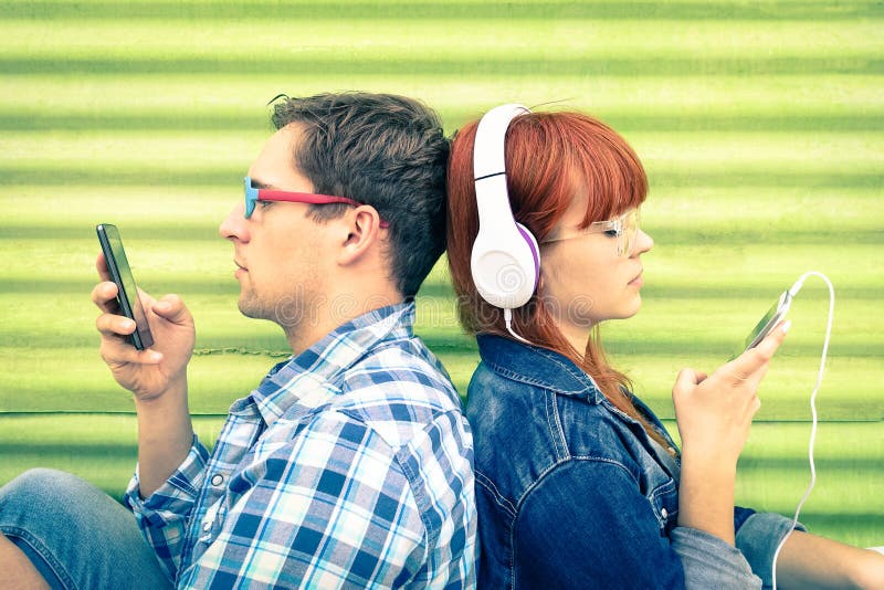 Ζεύγος Hipster στη στιγμή ανιδιοτέλειας με τα κινητά έξυπνα τηλέφωνα στοκ εικόνες με δικαίωμα ελεύθερης χρήσης Ζεύγος Hipster στη στιγμή ανιδιοτέλειας με τα κινητά έξυπνα τηλέφωνα στοκ εικόνες με δικαίωμα ελεύθερης χρήσης