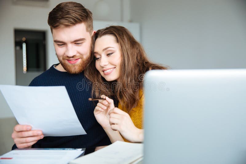 Ζεύγος που διαχειρίζεται τους λογαριασμούς τους στο σπίτι στοκ εικόνες Ζεύγος που διαχειρίζεται τους λογαριασμούς τους στο σπίτι στοκ εικόνες