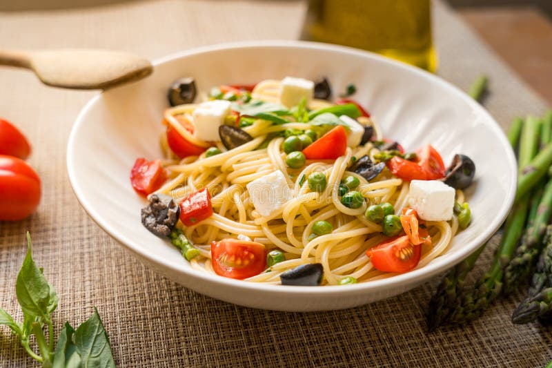 Ζυμαρικά ζυμαρικά Pasta primavera κοντά με ντομάτες κεράσι μαύρη ελιές φέτα στοκ εικόνες