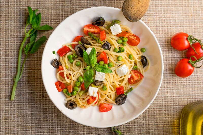 Ζυμαρικά ζυμαρικά Pasta primavera κοντά με ντομάτες κεράσι μαύρη ελιές φέτα στοκ φωτογραφία