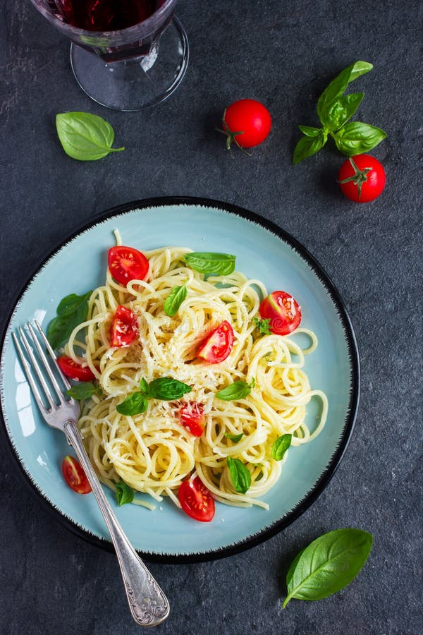Ζυμαρικά Spaghetty με τις ντομάτες κερασιών, τα chees βασιλικού και παρμεζάνας στοκ φωτογραφίες
