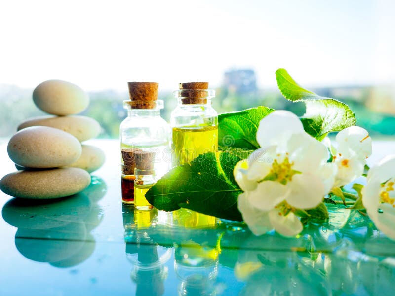 Ζωή SPA ακόμα με lavender το έλαιο και τα λουλούδια στον ξύλινο πίνακα, στο ελαφρύ υπόβαθρο, τα aromatherapy ουσιαστικά έλαια στα στοκ φωτογραφία