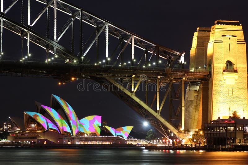 Lighted Sydney Harbour Bridge with colourful illuminated Opera House by night at the Festival of Lights event. Long exposure shot. Lighted Sydney Harbour Bridge with colourful illuminated Opera House by night at the Festival of Lights event. Long exposure shot