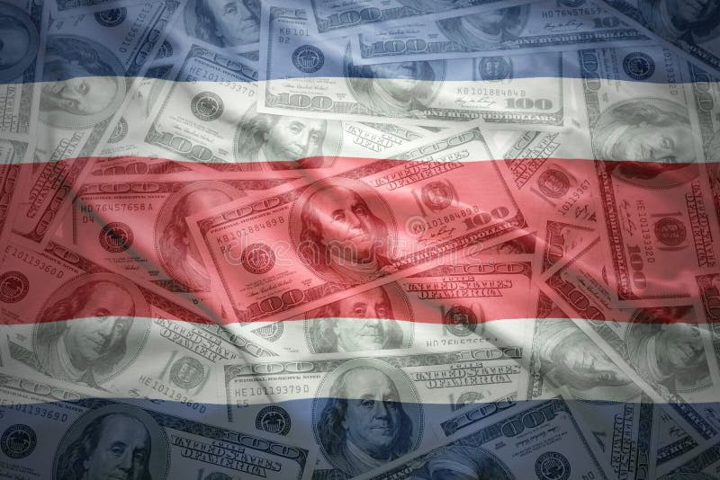 Ζωηρόχρωμη κυματίζοντας από την Κόστα Ρίκα σημαία σε ένα υπόβαθρο χρημάτων δολαρίων στοκ φωτογραφία Ζωηρόχρωμη κυματίζοντας από την Κόστα Ρίκα σημαία σε ένα υπόβαθρο χρημάτων δολαρίων στοκ φωτογραφία