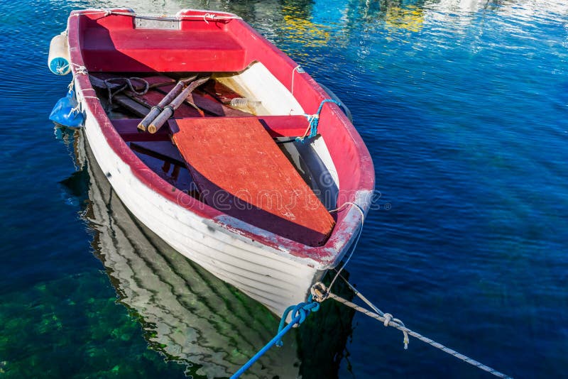 Η άποψη μιας ζωηρόχρωμης ξύλινης βάρκας έδεσε στη μαρίνα σε μια σαφή μπλε θάλασσα στοκ φωτογραφία με δικαίωμα ελεύθερης χρήσης Η άποψη μιας ζωηρόχρωμης ξύλινης βάρκας έδεσε στη μαρίνα σε μια σαφή μπλε θάλασσα στοκ φωτογραφία με δικαίωμα ελεύθερης χρήσης