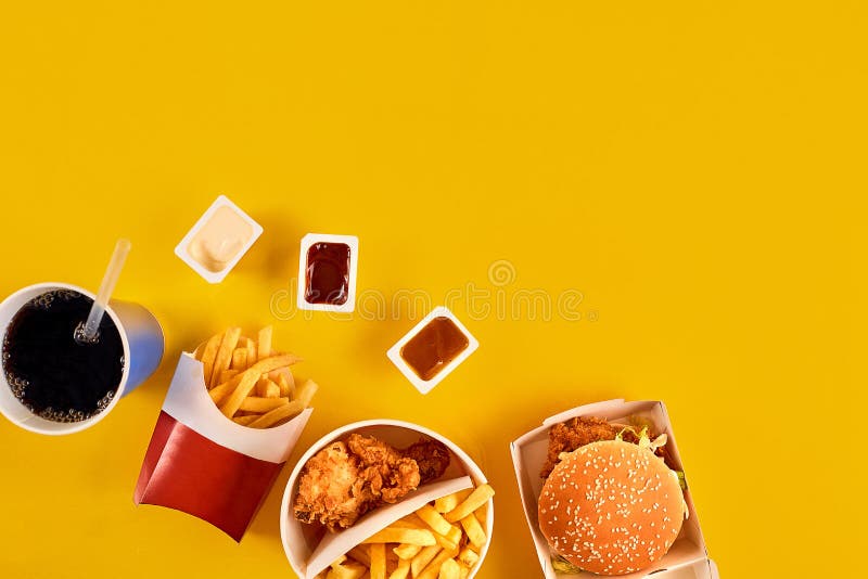 Η έννοια γρήγορου φαγητού με το λιπαρό τηγανισμένο εστιατόριο παίρνει έξω ως δαχτυλίδια κρεμμυδιών, burger, τηγανισμένες κοτόπουλ