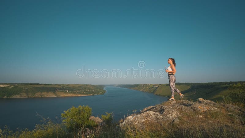 η αθλητική γυναίκα που στέκεται σε ένα όμορφο ποτάμιο φόντο. στοκ εικόνα με δικαίωμα ελεύθερης χρήσης