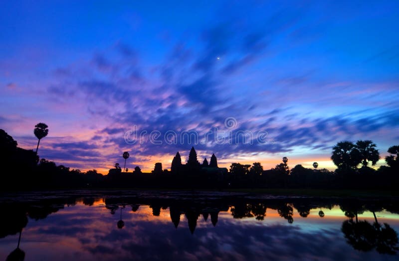 Sunrise shot of Ankor Wat in Siem Reap, Cambodia where tourists gather early as 5 am to catch the sun's first rays behind the ancient temple. Sunrise shot of Ankor Wat in Siem Reap, Cambodia where tourists gather early as 5 am to catch the sun's first rays behind the ancient temple