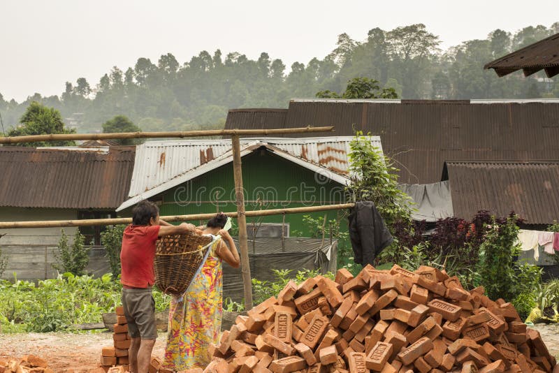 8th April, 2022, Kalimpong, West Bengal, India: Nepali male and female villager carrying bricks to build their home at Kalimpong. 8th April, 2022, Kalimpong, West Bengal, India: Nepali male and female villager carrying bricks to build their home at Kalimpong