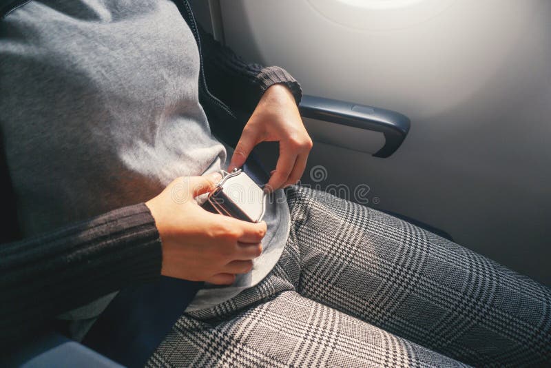 Η ασιατική γυναίκα έννοιας ασφάλειας στερεώνει τη ζώνη ασφαλείας στο αεροπλάνο έτοιμο να απογειωθεί στοκ εικόνα με δικαίωμα ελεύθερης χρήσης Η ασιατική γυναίκα έννοιας ασφάλειας στερεώνει τη ζώνη ασφαλείας στο αεροπλάνο έτοιμο να απογειωθεί στοκ εικόνα με δικαίωμα ελεύθερης χρήσης