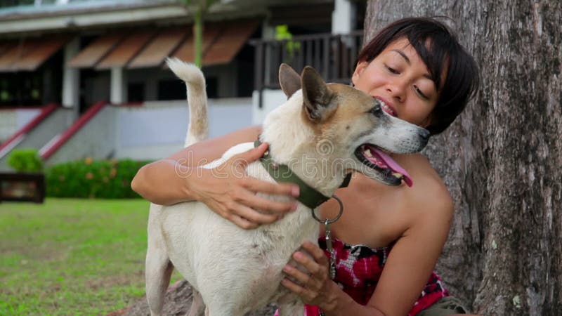 Η ασιατική γυναίκα ασκεί το σκυλί της