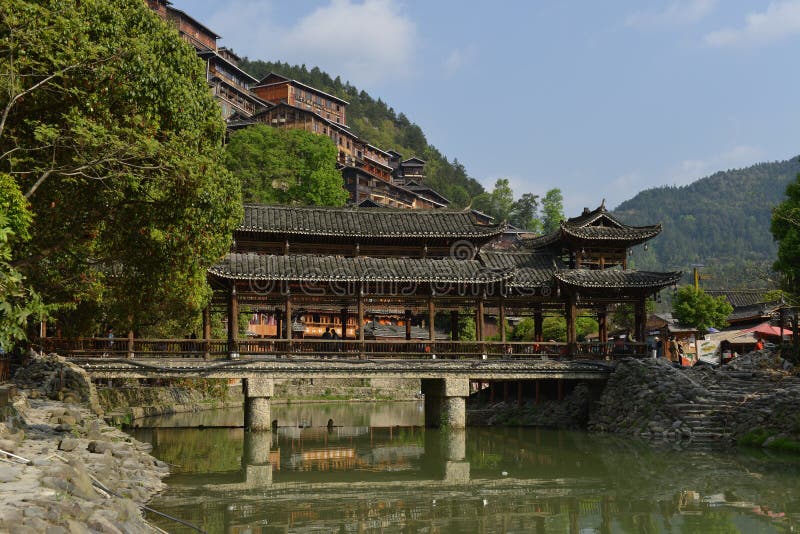 Located on the north side of Leigong Hill, Xijiang Qianhu Miao Village is about 35 km 22 miles away from Kaili city; the capital of Qiandongnan, and about 260 km 162 miles from Guiyang City; the capital city of Guizhou Province. Being the largest gathering place of the Miao in China and even the world, about ten natural Miao ethnic villages exist in Xijiang Town and the Miao culture is best preserved in this area. According to the latest statistics, there are about 1,288 families with a total population of around 6,000 people living there. 99.5% of the local people are Miao nationality. Fengyu bridge Wind-rain bridge plays an important role there. It is built by Miao people in the purpose of improving living conditions and protecting local environment. There are five Fengyu bridges made of the mixed construction of cement and wood. These bridges can connect the banks of the river and withstand flood. Located on the north side of Leigong Hill, Xijiang Qianhu Miao Village is about 35 km 22 miles away from Kaili city; the capital of Qiandongnan, and about 260 km 162 miles from Guiyang City; the capital city of Guizhou Province. Being the largest gathering place of the Miao in China and even the world, about ten natural Miao ethnic villages exist in Xijiang Town and the Miao culture is best preserved in this area. According to the latest statistics, there are about 1,288 families with a total population of around 6,000 people living there. 99.5% of the local people are Miao nationality. Fengyu bridge Wind-rain bridge plays an important role there. It is built by Miao people in the purpose of improving living conditions and protecting local environment. There are five Fengyu bridges made of the mixed construction of cement and wood. These bridges can connect the banks of the river and withstand flood.