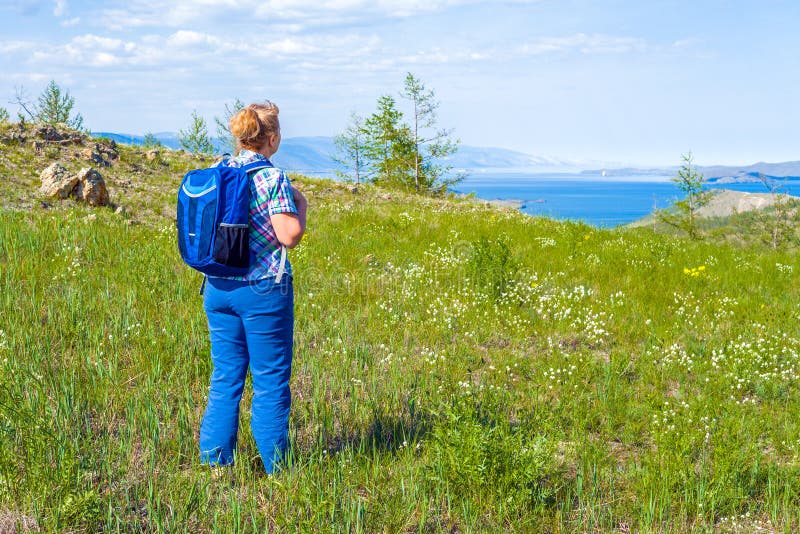 Η γυναίκα backpacker ήρθε σε μια μεγάλη λίμνη στοκ εικόνα