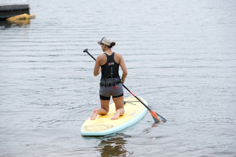 Woman kneeling on a paddleboarding in Bayou Texar in Pensacola, Florida. Woman kneeling on a paddleboarding in Bayou Texar in Pensacola, Florida