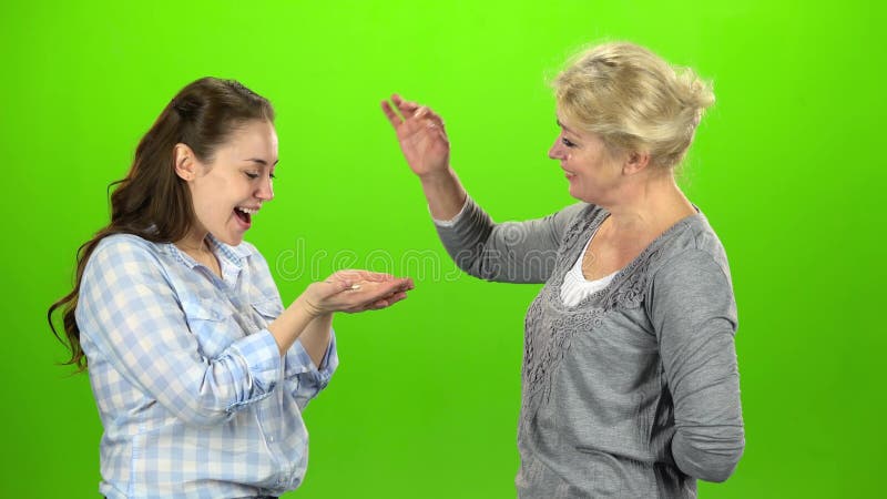 Η γυναίκα δίνει τα κλειδιά στην κόρη της πράσινη οθόνη Πλάγια όψη
