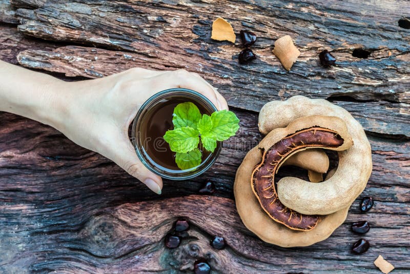 Η γυναίκα κρατά εύγευστο γλυκό tamarind ποτών στοκ φωτογραφίες με δικαίωμα ελεύθερης χρήσης Η γυναίκα κρατά εύγευστο γλυκό tamarind ποτών στοκ φωτογραφίες με δικαίωμα ελεύθερης χρήσης