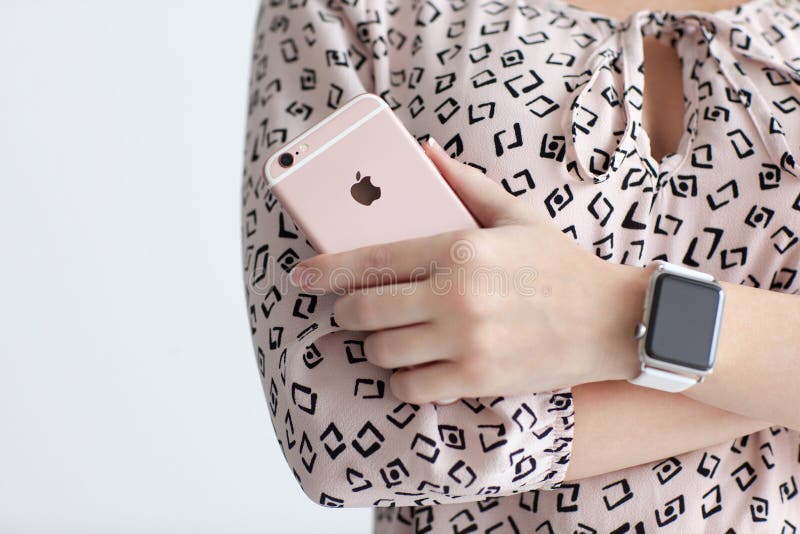 Η γυναίκα με το iPhone 6 S εκμετάλλευσης ρολογιών της Apple αυξήθηκε χρυσός στοκ εικόνες Η γυναίκα με το iPhone 6 S εκμετάλλευσης ρολογιών της Apple αυξήθηκε χρυσός στοκ εικόνες
