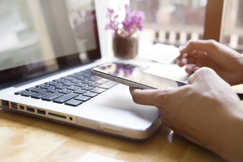 Η γυναίκα που χρησιμοποιούν το lap-top και το κινητό τηλέφωνο on-line να ψωνίσουν και πληρώνουν από την πιστωτική κάρτα στοκ φωτογραφία με δικαίωμα ελεύθερης χρήσης Η γυναίκα που χρησιμοποιούν το lap-top και το κινητό τηλέφωνο on-line να ψωνίσουν και πληρώνουν από την πιστωτική κάρτα στοκ φωτογραφία με δικαίωμα ελεύθερης χρήσης