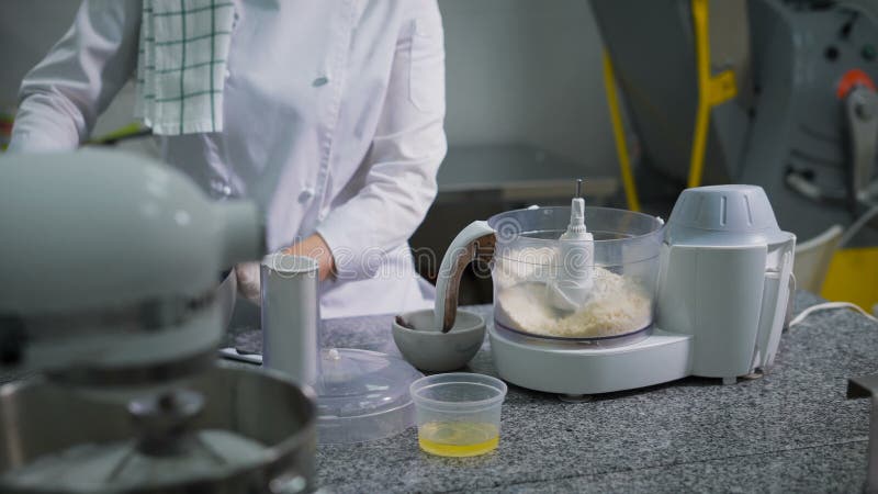 Η γυναίκα στην κουζίνα σε ένα κατάστημα καραμελών προετοιμάζει ένα επιδόρπιο Το κορίτσι στα γάντια προετοιμάζεται macaron Ο εργαζ απόθεμα βίντεο