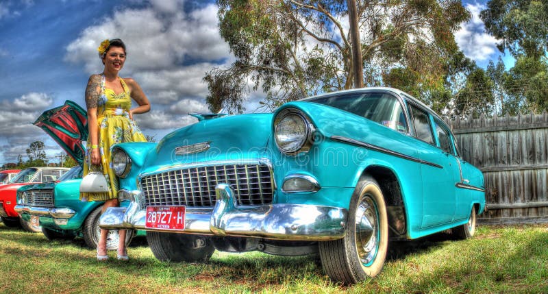 Classic American 1950s blue Chevy with woman in 1950s dress at car show in Melbourne, Australia . Classic American 1950s blue Chevy with woman in 1950s dress at car show in Melbourne, Australia .