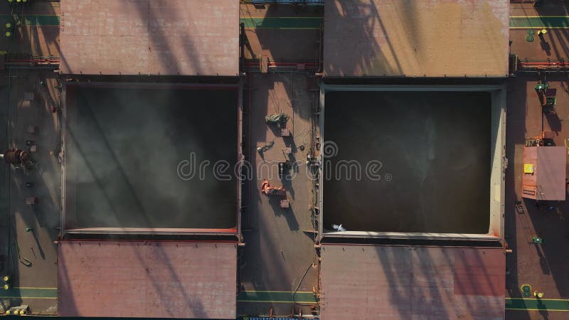 η εναέρια άποψη του μεγάλου πλοίου μεταφοράς χύδην φορτίου φορτώνεται με σιτάρι στο λιμάνι κατά το ηλιοβασίλεμα