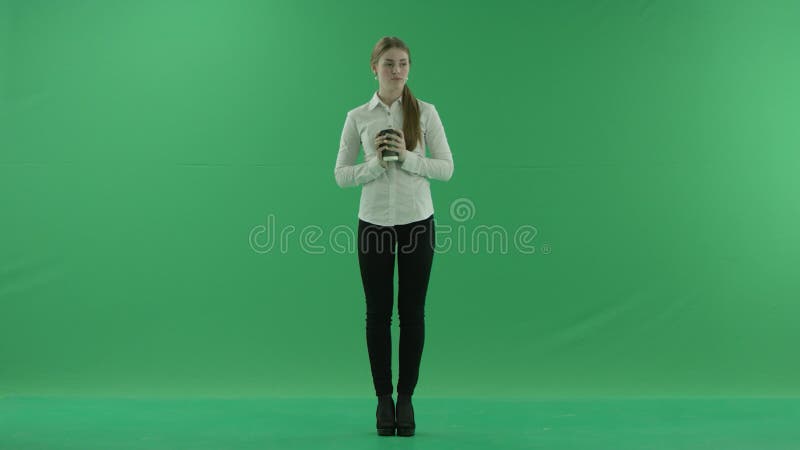Η επιχειρησιακή γυναίκα πίνει ένα φλιτζάνι του καφέ ή ένα τσάι Φορά το επίσημο φόρεμα: άσπρα πουκάμισο και blak παντελόνι r