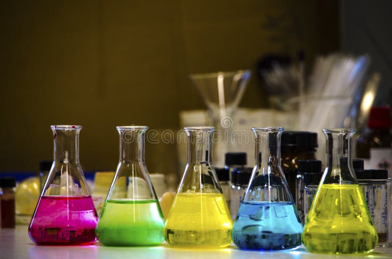 Η ζωηρόχρωμη λύση στην κωνική φιάλη ευθυγράμμισε σε έναν πάγκο σε ένα εργαστήριο χημείας με το οργανικό πείραμα χημείας υποβάθρου στοκ εικόνα με δικαίωμα ελεύθερης χρήσης Η ζωηρόχρωμη λύση στην κωνική φιάλη ευθυγράμμισε σε έναν πάγκο σε ένα εργαστήριο χημείας με το οργανικό πείραμα χημείας υποβάθρου στοκ εικόνα με δικαίωμα ελεύθερης χρήσης