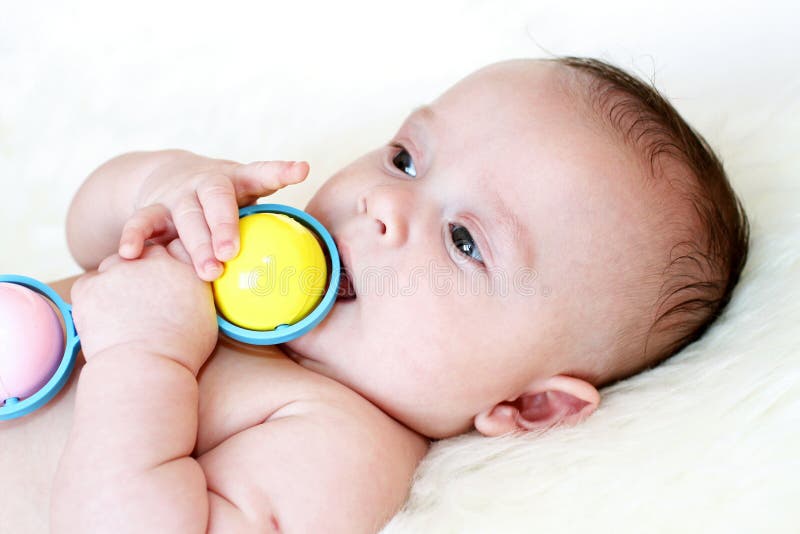 Lovely baby age of 3,5 months plays a rattle. Lovely baby age of 3,5 months plays a rattle