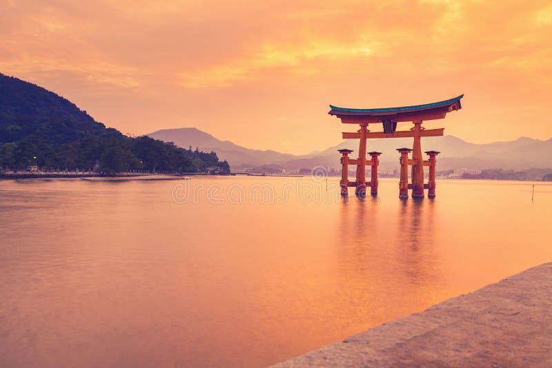 The famous orange floating shinto gate (Torii) of Itsukushima shrine, Miyajima island of Hiroshima prefecture, Japan at sunset. The famous orange floating shinto gate (Torii) of Itsukushima shrine, Miyajima island of Hiroshima prefecture, Japan at sunset.