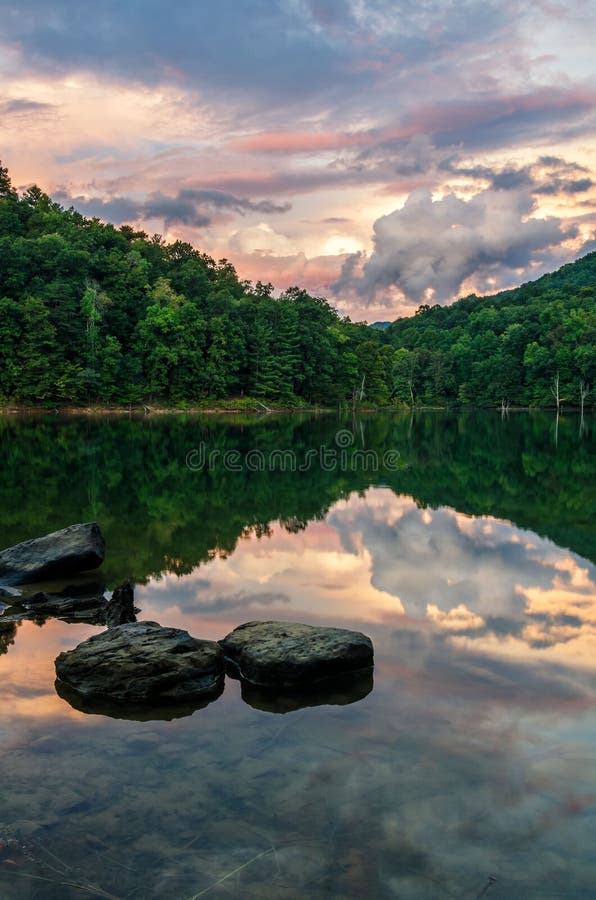 A beautiful pastel sunset reflects in the still waters of Martins Fork lake in the Appalachian Mountains of Kentucky. A beautiful pastel sunset reflects in the still waters of Martins Fork lake in the Appalachian Mountains of Kentucky.
