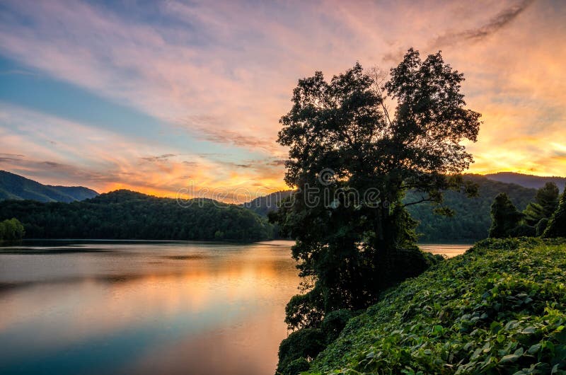 A beautiful sunset reflects on the surface of Martins Fork lake in the Appalachian Mountains of Kentucky. A beautiful sunset reflects on the surface of Martins Fork lake in the Appalachian Mountains of Kentucky.