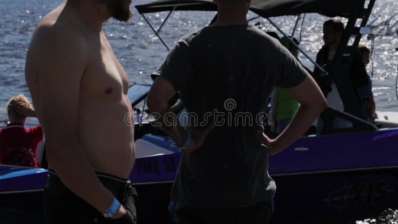 Η ιώδης βάρκα μηχανών με τη νέα γυναίκα επιπλέει το κοντινό σύνολο αποβαθρών των ανθρώπων στο καλοκαίρι απόθεμα βίντεο