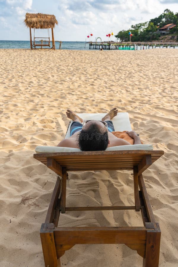 Η κάθετη φωτογραφία του ατόμου sunbath και χαλαρώνει στην όμορφη παραλία στοκ εικόνες Η κάθετη φωτογραφία του ατόμου sunbath και χαλαρώνει στην όμορφη παραλία στοκ εικόνες