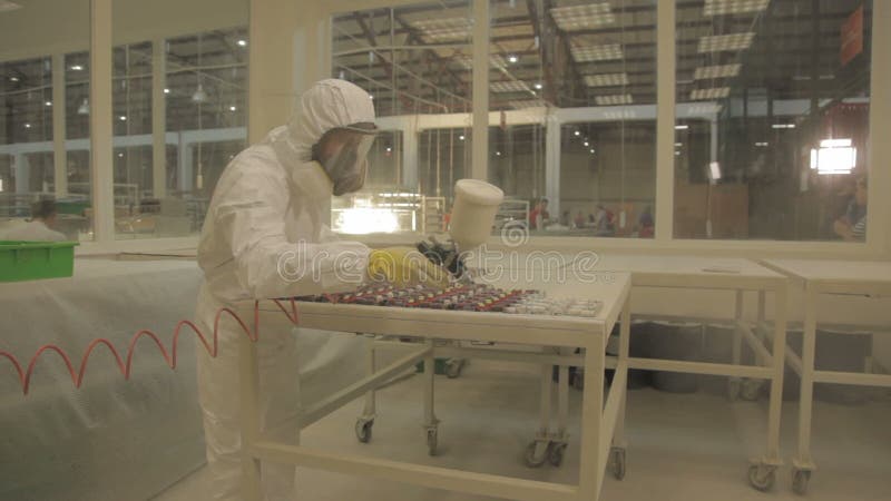 Η κάμερα κινηματογραφήσεων σε πρώτο πλάνο από το στοιχείο τσιπ στον εργαζόμενο μεταχειρίζεται το πυροβόλο όπλο ψεκασμού στις οδηγ απόθεμα βίντεο