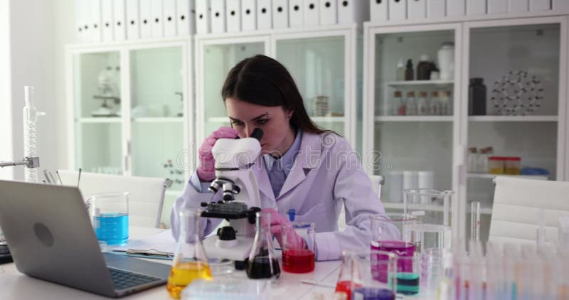 Η κυρία ερευνήτρια εξετάζει δείγματα εργαστηρίων στο μικροσκόπιο φιλμ μικρού μήκους