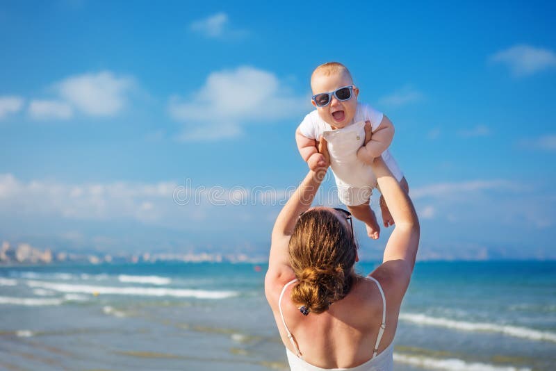 Η μητέρα και ο γιος της έχουν τη διασκέδαση στην παραλία θάλασσας στο ηλιοβασίλεμα στοκ φωτογραφίες Η μητέρα και ο γιος της έχουν τη διασκέδαση στην παραλία θάλασσας στο ηλιοβασίλεμα στοκ φωτογραφίες