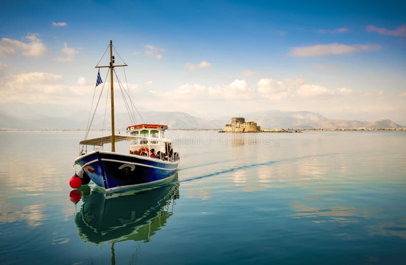 Η μικρή ξύλινη βάρκα μεταφέρει μια ομάδα τουριστών στο νησί Bourtzi μια αρχαία φυλακή Nafplion, Ελλάδα στοκ φωτογραφία με δικαίωμα ελεύθερης χρήσης Η μικρή ξύλινη βάρκα μεταφέρει μια ομάδα τουριστών στο νησί Bourtzi μια αρχαία φυλακή Nafplion, Ελλάδα στοκ φωτογραφία με δικαίωμα ελεύθερης χρήσης