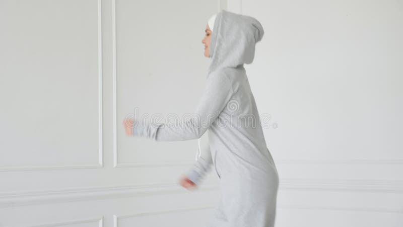 Η μουσουλμανική γυναίκα στο φόρεμα hijab και ικανότητας κάνει την άσκηση ικανότητας για τα πόδια