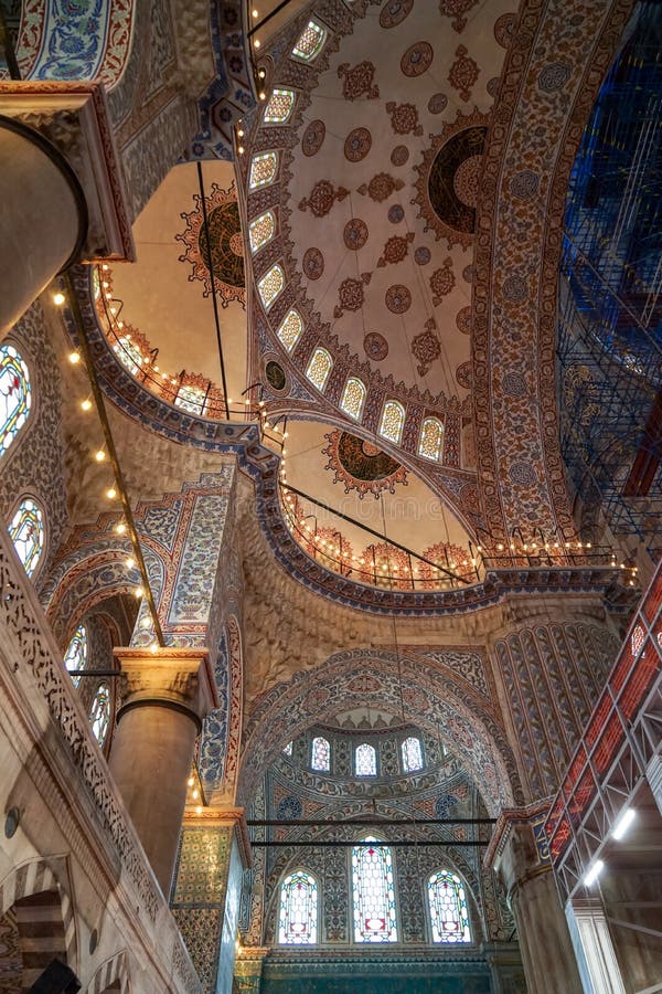 The blue mosque beautiful interior ornamental decoration of dome ceiling, arch windows and columns and lighting with historical restoration framework, selective focus, Istanbul, Turkey. The blue mosque beautiful interior ornamental decoration of dome ceiling, arch windows and columns and lighting with historical restoration framework, selective focus, Istanbul, Turkey