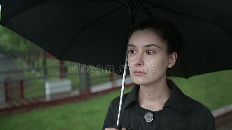 Η μόνη λυπημένη γυναίκα περπατά κάτω από την οδό στη δυνατή βροχή κίνηση αργή