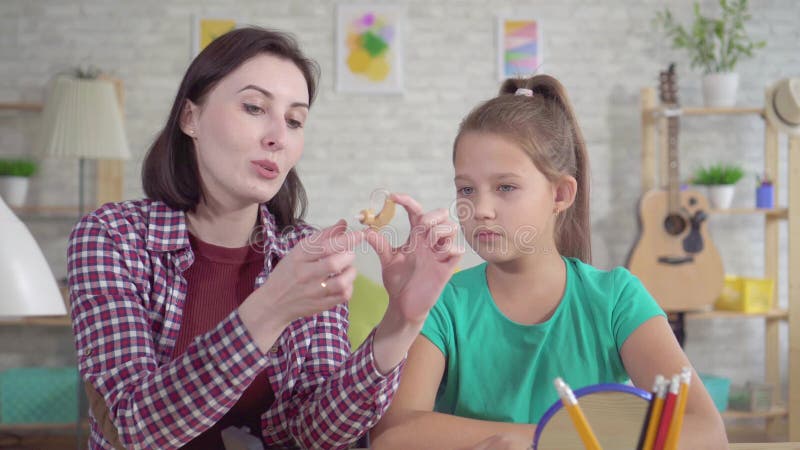 Η νέα γυναίκα λέει σε ένα έφηβη για μια ενίσχυση ακρόασης