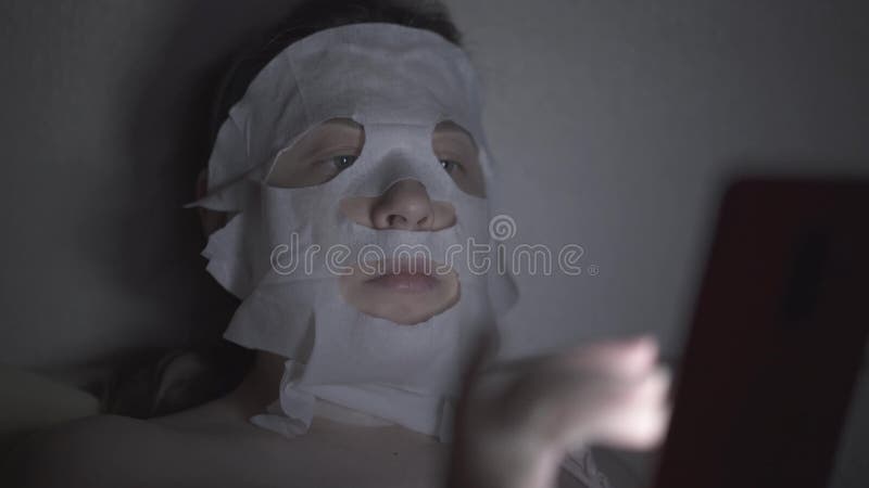 Η νέα γυναίκα στην αναπαραγωγή της μάσκας φύλλων βρίσκεται στο σκοτεινό δωμάτιο