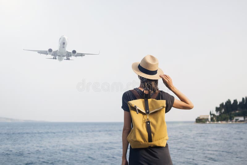 η νεαρή γυναίκα που κοιτάζει αεροπλάνο πάνω από το θαλάσσιο ταξίδι απολαμβάνει τη ζωή και την ενεργή έννοια του τρόπου ζωής στοκ εικόνα με δικαίωμα ελεύθερης χρήσης