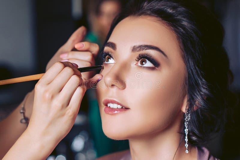 Η νύφη τίθεται στο makeup πριν από τη γαμήλια τελετή στοκ εικόνες