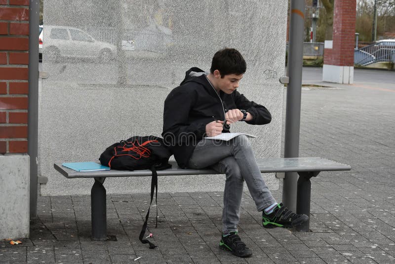 Η ξεχασμένη σχολική εργασία, αγόρι ελέγχει ότι ο χρόνος μέχρι το λεωφορείο θα φθάσει στοκ εικόνα Η ξεχασμένη σχολική εργασία, αγόρι ελέγχει ότι ο χρόνος μέχρι το λεωφορείο θα φθάσει στοκ εικόνα