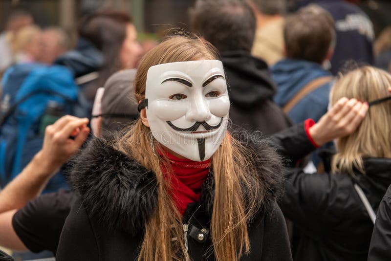 Η ομάδα νέων έντυσε όλων στο Μαύρο βγαίνει στην οδό για να καταδείξει με τις ανώνυμες μάσκες στοκ φωτογραφία με δικαίωμα ελεύθερης χρήσης Η ομάδα νέων έντυσε όλων στο Μαύρο βγαίνει στην οδό για να καταδείξει με τις ανώνυμες μάσκες στοκ φωτογραφία με δικαίωμα ελεύθερης χρήσης
