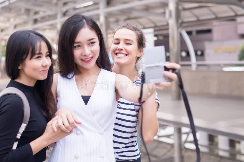 Η ομάδα ταξιδιώτη γυναικών κάνει το selfie της στην κεντρική οδό, όμορφο θηλυκό που περπατά στις οδούς, ευτυχής και που χαμογελά στοκ φωτογραφία με δικαίωμα ελεύθερης χρήσης Η ομάδα ταξιδιώτη γυναικών κάνει το selfie της στην κεντρική οδό, όμορφο θηλυκό που περπατά στις οδούς, ευτυχής και που χαμογελά στοκ φωτογραφία με δικαίωμα ελεύθερης χρήσης