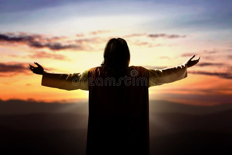 Η πίσω όψη του Ιησού Χριστού σήκωσε τα χέρια και προσεύχεται στο Θεό